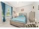 Comfortable bedroom with a ceiling fan, natural light and patterned chair at 19115 Sw 98Th Loop, Dunnellon, FL 34432