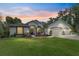 Charming one-story home with a well-manicured lawn and a three car garage, illuminated by twilight at 19115 Sw 98Th Loop, Dunnellon, FL 34432