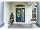 Welcoming blue front door with decorative wreath, sidelight window, and charming welcome mat at 19115 Sw 98Th Loop, Dunnellon, FL 34432