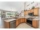 Open kitchen with stainless appliances and light wood cabinets overlooking dining area at 19115 Sw 98Th Loop, Dunnellon, FL 34432