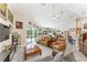 Bright open-plan living room with tile flooring, ceiling fan, and view of the pool area at 19115 Sw 98Th Loop, Dunnellon, FL 34432