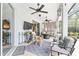 Covered patio with ceiling fans, comfortable seating, and a mounted television for outdoor enjoyment at 19115 Sw 98Th Loop, Dunnellon, FL 34432