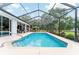 Lovely pool area featuring a screened enclosure, lush landscaping, and ample space for entertaining at 19115 Sw 98Th Loop, Dunnellon, FL 34432
