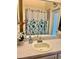 Bathroom vanity with an oval sink, beige countertop and floral shower curtain reflected in the mirror at 19480 Sw 100Th Loop, Dunnellon, FL 34432