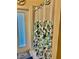 Shower with a floral shower curtain in a bathroom with an exit door to the lanai at 19480 Sw 100Th Loop, Dunnellon, FL 34432
