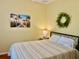Bedroom featuring yellow walls, stripped bedding, and a wrought iron bedframe with palm tree wall decor at 19480 Sw 100Th Loop, Dunnellon, FL 34432