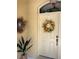 Close-up of front door, decorated with seasonal wreaths and a lush potted plant for a welcoming entrance at 19480 Sw 100Th Loop, Dunnellon, FL 34432