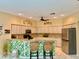 The combined kitchen and seating area feature barstools, stainless appliances, light cabinetry and plenty of light at 19480 Sw 100Th Loop, Dunnellon, FL 34432