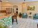 Kitchen and seating area feature barstools, stainless appliances, light cabinetry and plenty of light and neutral colors at 19480 Sw 100Th Loop, Dunnellon, FL 34432