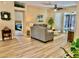 Inviting living room featuring wood floors, neutral furniture, and a view into an adjacent bedroom at 19480 Sw 100Th Loop, Dunnellon, FL 34432