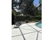 Relaxing pool deck featuring outdoor seating and a screened enclosure with views of the lush backyard at 19480 Sw 100Th Loop, Dunnellon, FL 34432