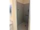 Modern shower stall featuring a tiled wall, grab bar, and glass door at 19480 Sw 100Th Loop, Dunnellon, FL 34432