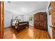 Bedroom with wooden floors, two windows, and a dark wood armoire at 26 Count Fleet Dr, Ocala, FL 34482