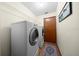 Laundry room featuring modern, front-loading washer and dryer set, shelving and tile flooring at 26 Count Fleet Dr, Ocala, FL 34482