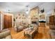 Comfortable living room featuring hardwood floors, brick fireplace, and a ceiling fan at 26 Count Fleet Dr, Ocala, FL 34482