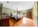 Spacious bedroom with wood floors, four-poster bed, neutral-colored walls, and ample natural light at 26 Count Fleet Dr, Ocala, FL 34482
