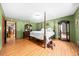 Spacious bedroom with wood floors, four-poster bed, neutral-colored walls, and ample closet space at 26 Count Fleet Dr, Ocala, FL 34482