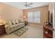 Cozy bedroom featuring wood floors, a comfortable sofa, and natural light from the window at 2721 Day Lily Run, The Villages, FL 32162