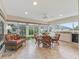 Sunroom with tile floor, glass table, wicker chairs, and lots of natural light at 2721 Day Lily Run, The Villages, FL 32162
