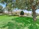 Back side of the home with mature trees and well-maintained lawn at 2721 Day Lily Run, The Villages, FL 32162