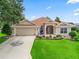 Lovely home with front yard, two-car garage, and an inviting front entrance at 2721 Day Lily Run, The Villages, FL 32162