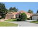 Charming home nestled among lush greenery, featuring a well-manicured lawn and a two-car garage at 2721 Day Lily Run, The Villages, FL 32162
