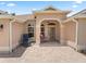 Front exterior showcasing a covered porch, a well-manicured garden, and a decorative driveway at 2721 Day Lily Run, The Villages, FL 32162