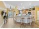 Stylish kitchen bar with seating overlooking the kitchen and entryway, featuring modern lighting and decor at 2721 Day Lily Run, The Villages, FL 32162