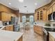 Spacious kitchen featuring wood cabinetry, stainless steel appliances, and a cozy breakfast nook with plenty of natural light at 2721 Day Lily Run, The Villages, FL 32162