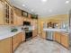 Well-appointed kitchen featuring modern appliances, light wood cabinets, and granite countertops with ample space at 2721 Day Lily Run, The Villages, FL 32162
