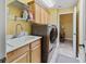 Well-equipped laundry room with modern washer/dryer and ample cabinet space at 2721 Day Lily Run, The Villages, FL 32162