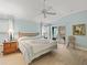 Bright main bedroom with wood floors and a view to the sun room from the sliding glass door at 2721 Day Lily Run, The Villages, FL 32162