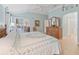 Light-filled main bedroom featuring wood floors, a ceiling fan, and a sliding glass door to a sunroom at 2721 Day Lily Run, The Villages, FL 32162