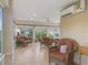Bright sunroom with tile floors, multiple windows, wicker furniture, and a ceiling fan at 2721 Day Lily Run, The Villages, FL 32162