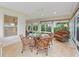 Bright sunroom with tile floors, multiple windows, wicker furniture, and a ceiling fan at 2721 Day Lily Run, The Villages, FL 32162
