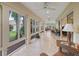 Spacious sunroom featuring tile flooring, many windows, and ceiling fans at 2721 Day Lily Run, The Villages, FL 32162