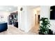A hallway with tile flooring and white walls leads to a kitchen with black cabinets and stainless appliances at 2883 Sw 146Th Place Rd, Ocala, FL 34473