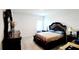 Bedroom featuring a large ornate bed, dark wood furniture, and tiled flooring at 2883 Sw 146Th Place Rd, Ocala, FL 34473
