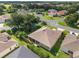 Aerial view featuring the home's backyard with mature trees and lush landscaping at 3001 Hillside Ln, The Villages, FL 32162