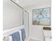 Bathroom featuring a tiled shower with glass door, toilet, towel bar and seaside artwork at 3001 Hillside Ln, The Villages, FL 32162