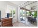 Bedroom with a shuttered window, side table, and sliding glass doors to the lanai with outdoor furniture at 3001 Hillside Ln, The Villages, FL 32162