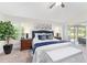 Primary bedroom with a ceiling fan, shuttered windows, and sliding glass doors to the lanai at 3001 Hillside Ln, The Villages, FL 32162