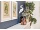 Close-up of botanical prints, a decorative bird, violin, and a decorative lantern on a white credenza at 3001 Hillside Ln, The Villages, FL 32162