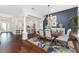Bright, open-concept dining area featuring dark hardwood floors, white pillars, and an adjacent kitchen at 3001 Hillside Ln, The Villages, FL 32162