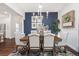 Dining area featuring a wooden table with upholstered chairs, a navy accent wall, and dark, hardwood floors at 3001 Hillside Ln, The Villages, FL 32162