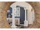 Dining room with white pillars seen through a decorative mirror, framed botanical prints, and dark accent wall at 3001 Hillside Ln, The Villages, FL 32162