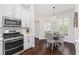 Kitchen with stainless steel range, microwave, and adjacent dining area with shuttered windows at 3001 Hillside Ln, The Villages, FL 32162