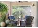 Relaxing sunroom filled with natural light, comfortable wicker furniture, and lush tropical plants at 3001 Hillside Ln, The Villages, FL 32162