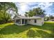 View of the back of the home featuring an enclosed porch and well-maintained yard at 42 Almond Dr, Ocala, FL 34472