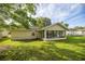 Back exterior of home with lawn, and sunroom featuring lots of windows for viewing the beautiful backyard at 42 Almond Dr, Ocala, FL 34472
